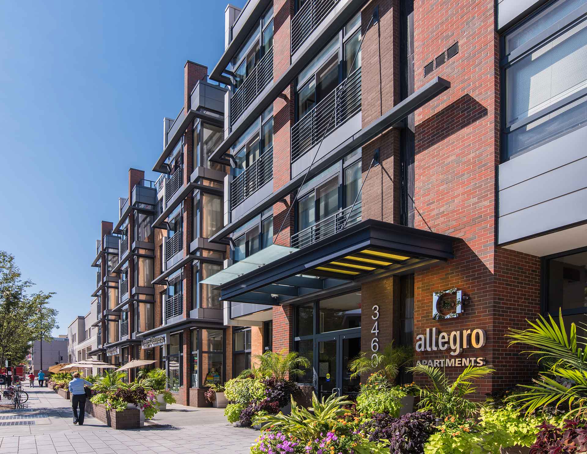Sidewalk view of Allegro building and entrance on 14th Street facing South on a sunny day