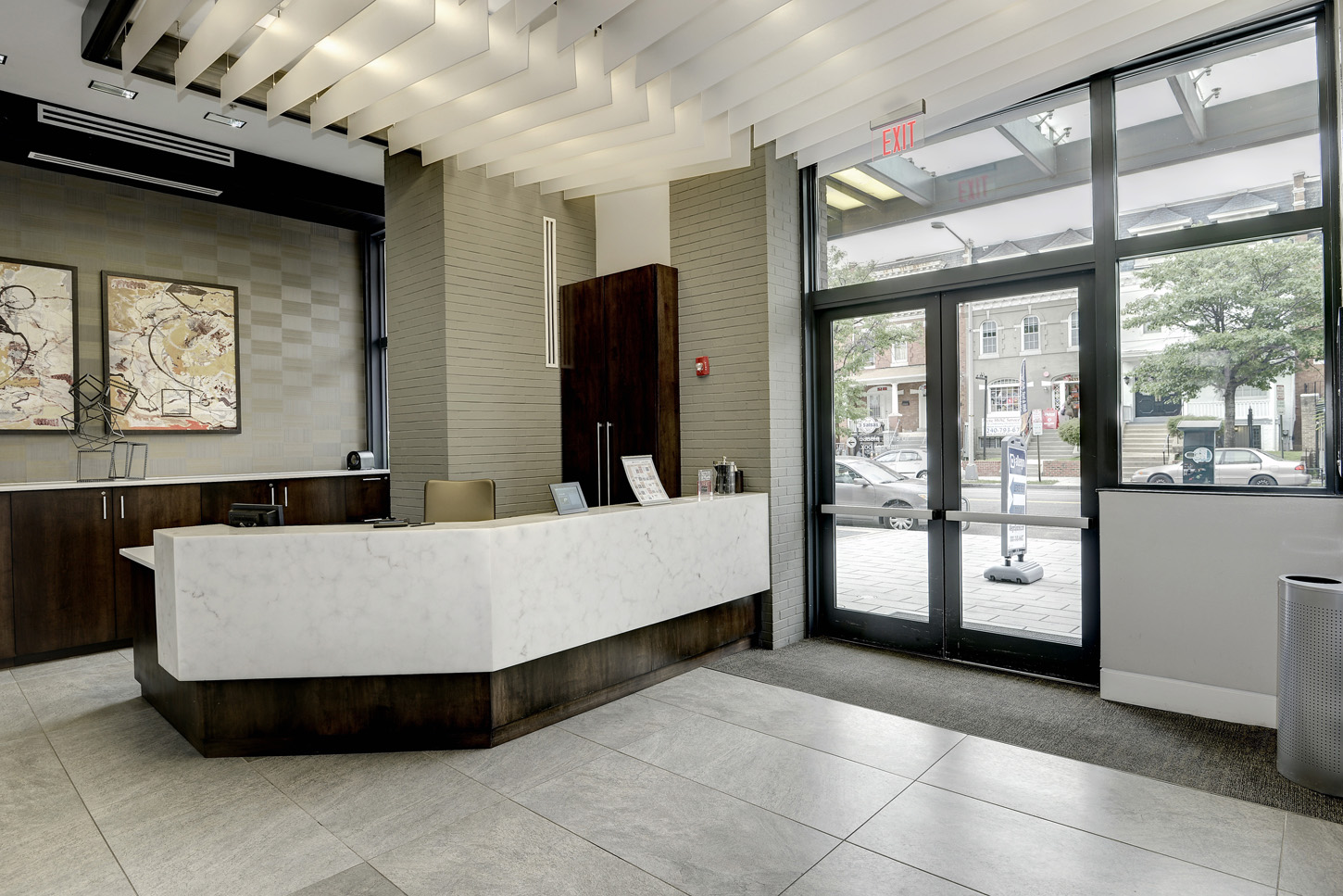 Lobby entrance with large marble concierge desk and abstract art behind it