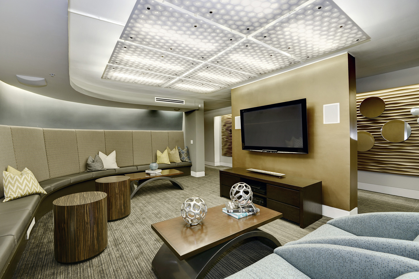 Entertainment center lounge with banquette seating and armchairs, with open hallway beyond