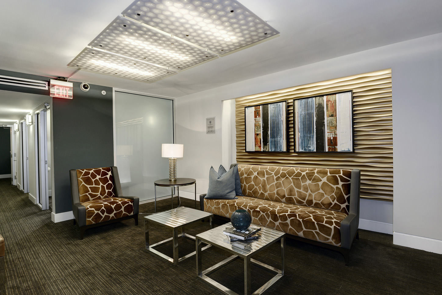 Clubroom hallway with graphic patterned sofa and chair, and entry to conference rooms to the left