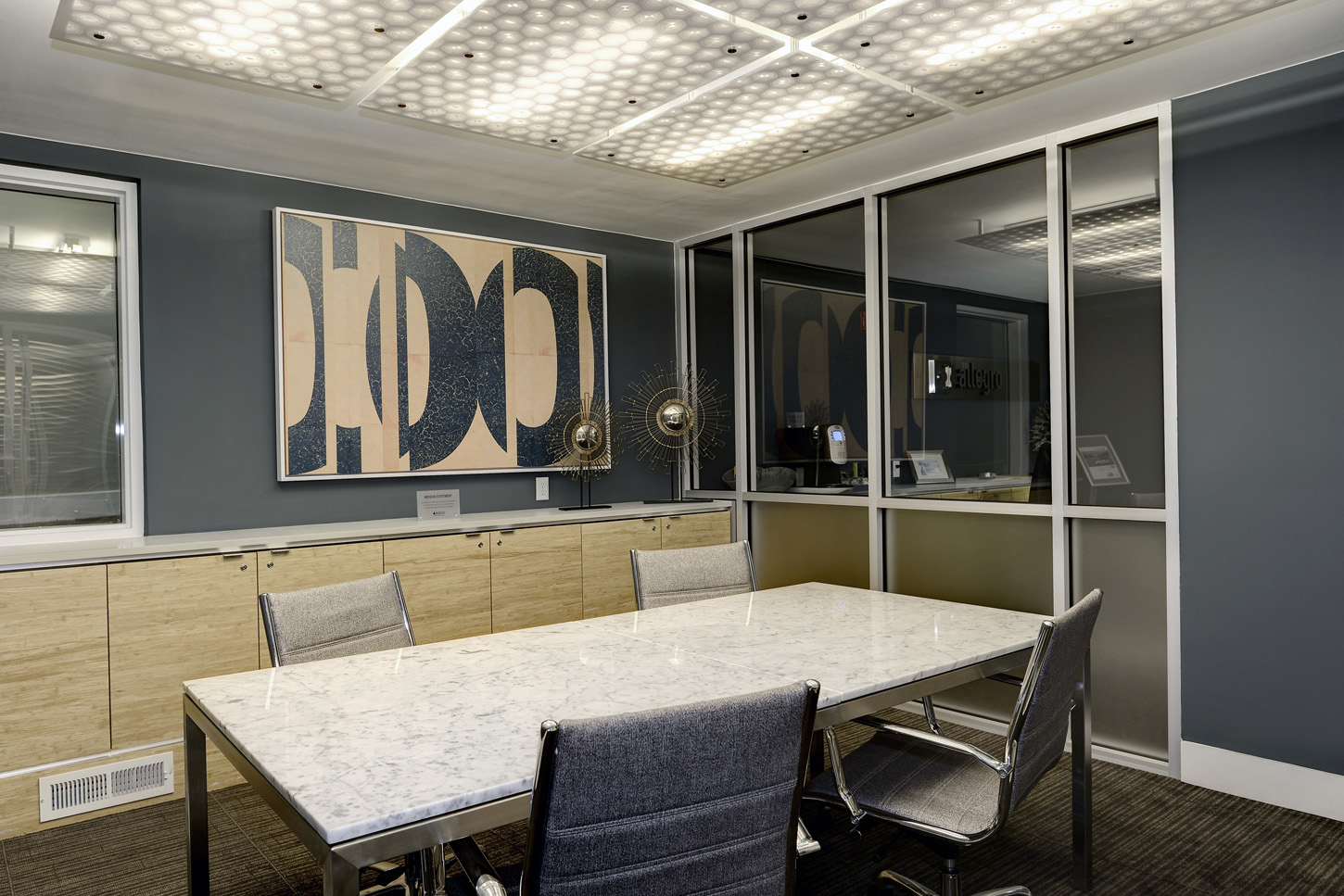 Brightly lit conferencing room with large table and shelving for catering or storage